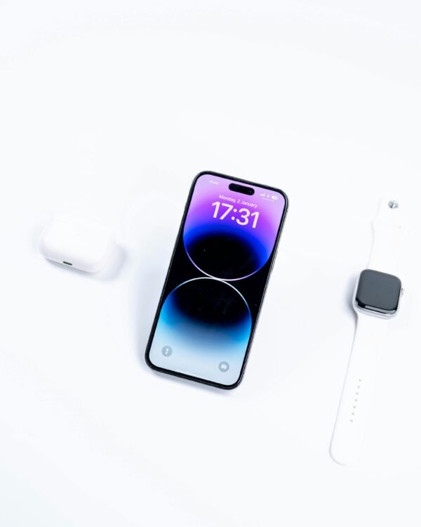 Chic flatlay featuring a smartphone, smartwatch, and earbuds on a sleek white background.